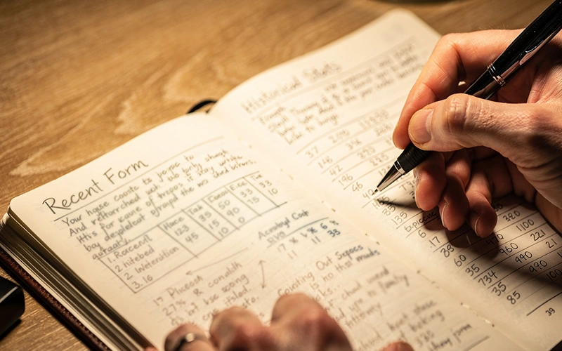 Personne analysant des données de performance dans un carnet pour prendre une décision