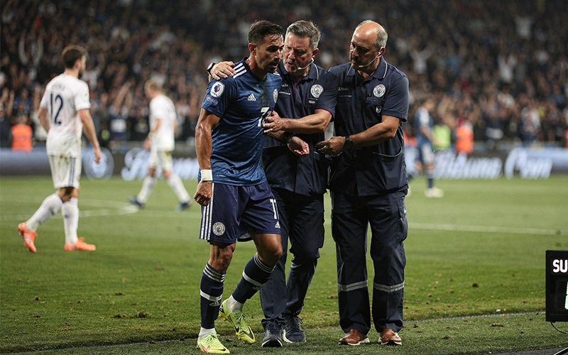 Défenseur blessé quittant le terrain soutenu par le staff