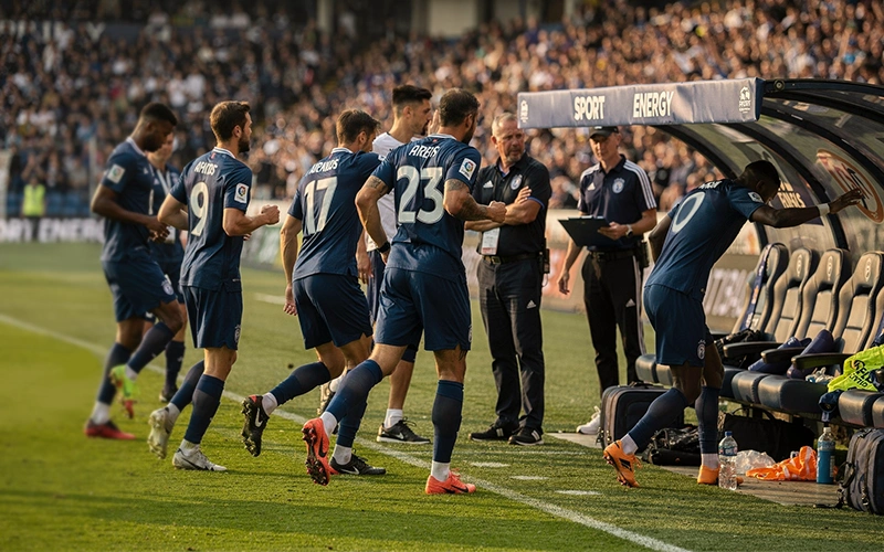 Banc de touche avec remplaçants se préparant à entrer en jeu