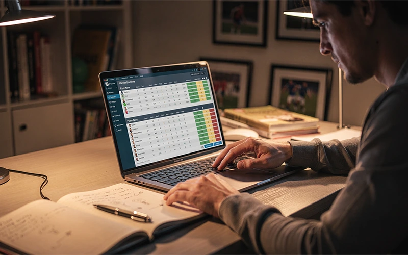 Personne consultant des statistiques de football sur un ordinateur portable